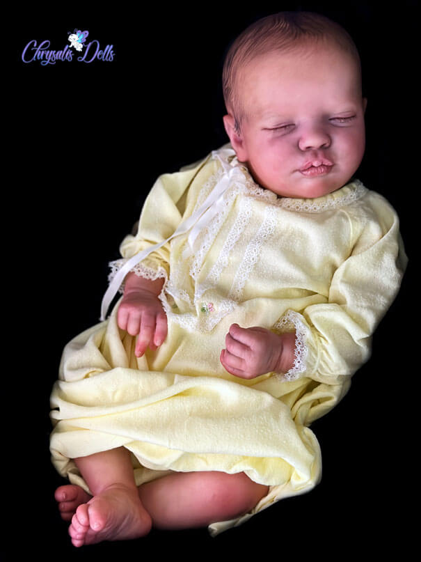 Realborn Priscilla sleeping in a yellow and white vintage gown.